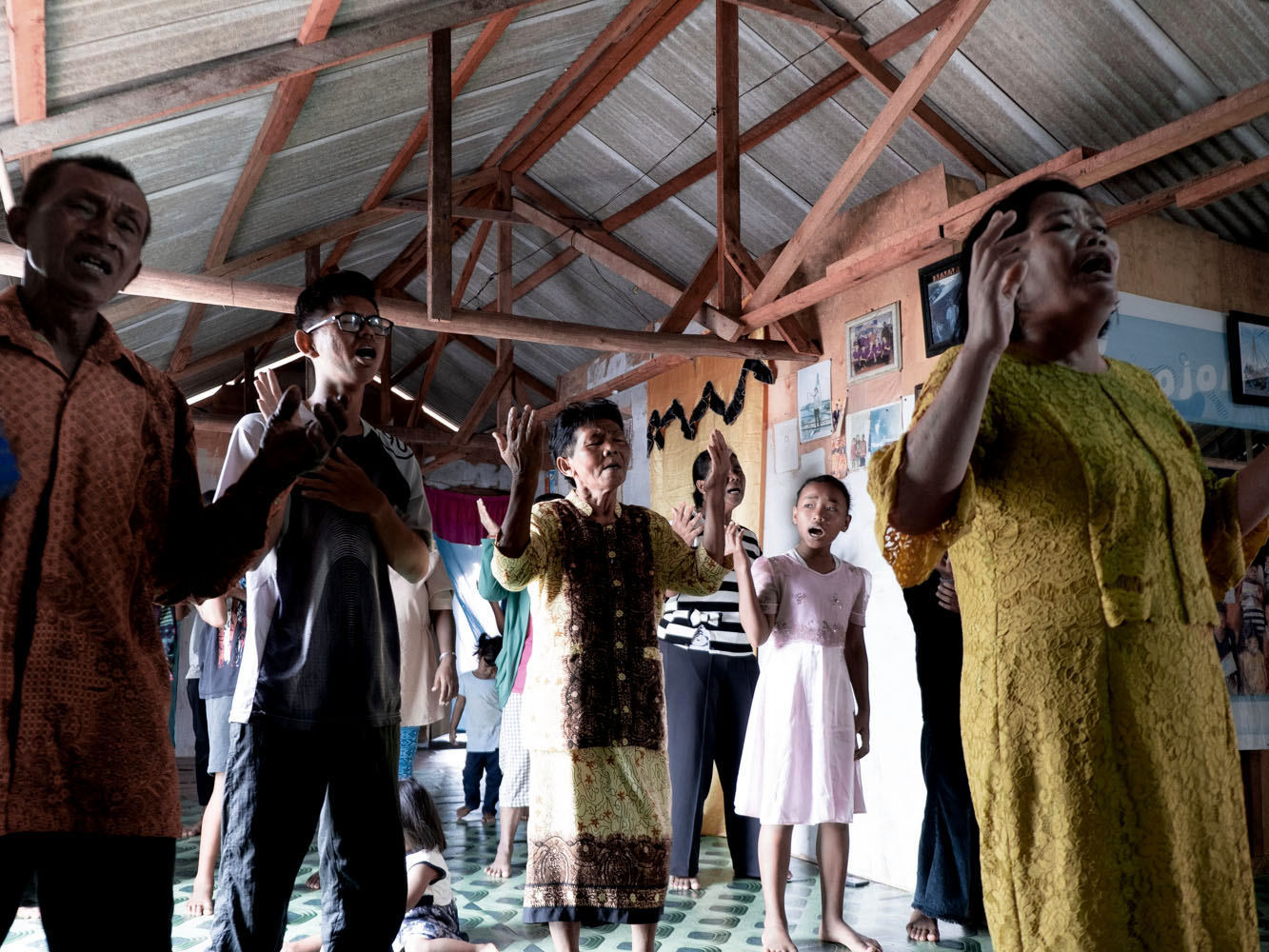Orang Laut residents in Tanjung Gundap attend a Sunday service led by the Indonesian Bethel Church (GBI) at the home of the community's leader. Since settling on land, many Orang Laut have gradually moved away from animist beliefs and embraced Islam and Christianity.