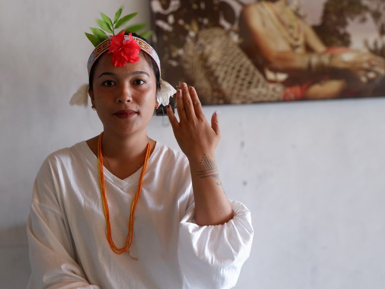 Ardila Saleleubaja, 26, from Maileppet Village in South Siberut, shows her tattoos, which feature an intricate combination of traditional Mentawai tattoo designs, including fishing hooks, stars, and uma rooftops, to showcase her identity as a Mentawai person.