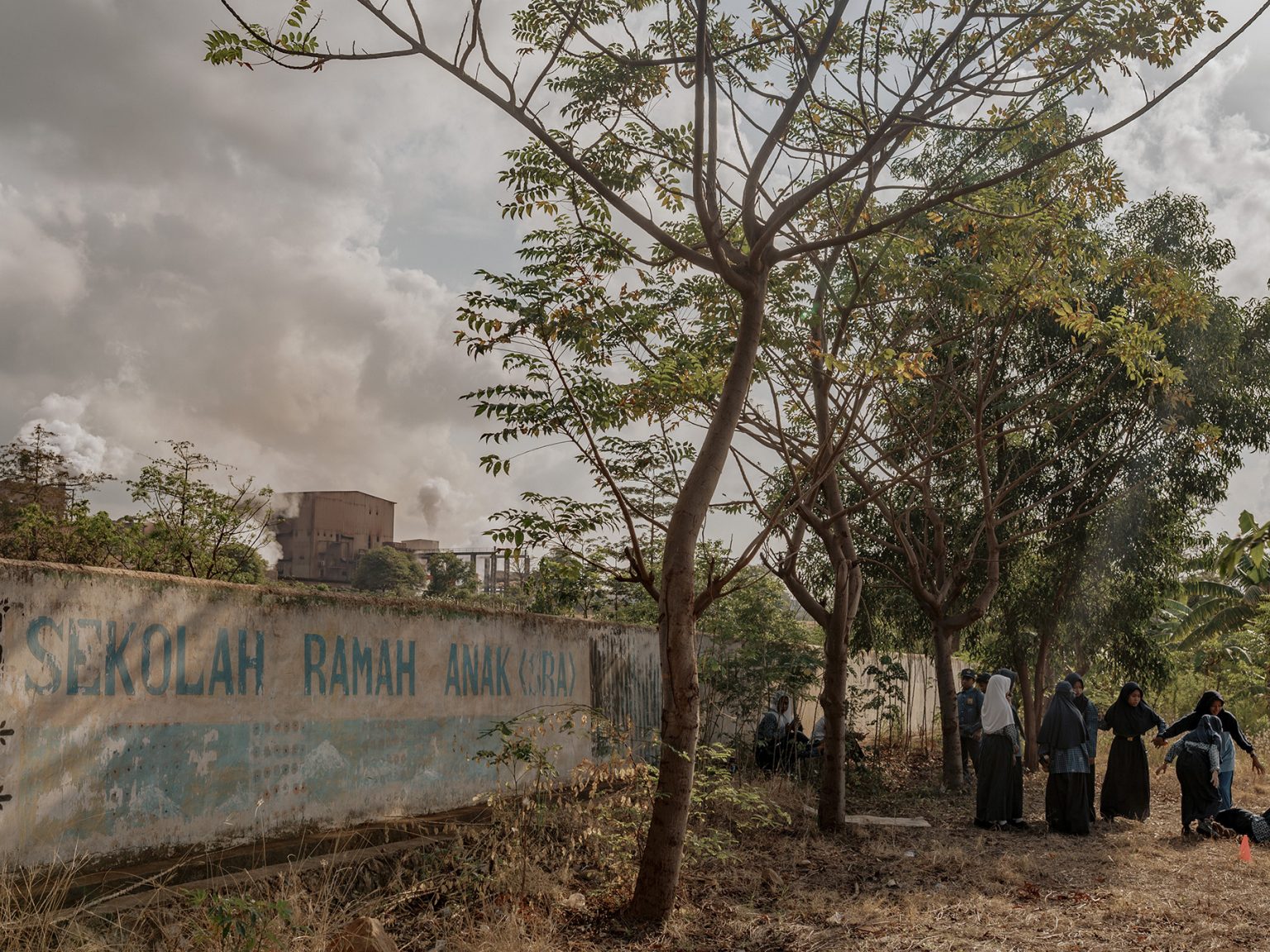 Students at Pa’jukukang State Junior High School (SMPN) 3 play on the school field without masks, even though the school sits beside a nickel smelter complex that sends dust and stench into the air.
