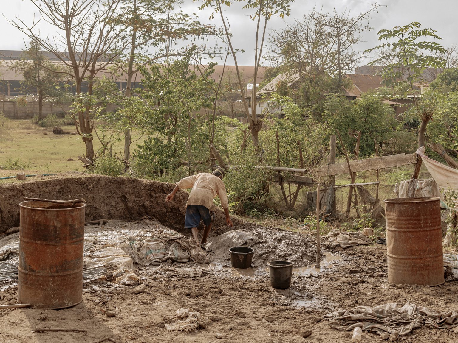 Ambo Enre mixes soil to mold bricks. To make ends meet, he now works as a brickmaker at a neighbor’s small home workshop. He remembers Papanloe as a green, quiet village, where families farmed small plots behind their houses, growing chili peppers, vegetables, and cassava.