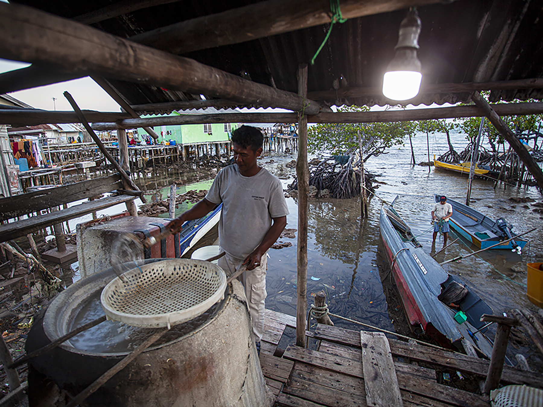 seorang nelayan merebus ikan teri di pulau mubud, karas, batam, kepulauan riau