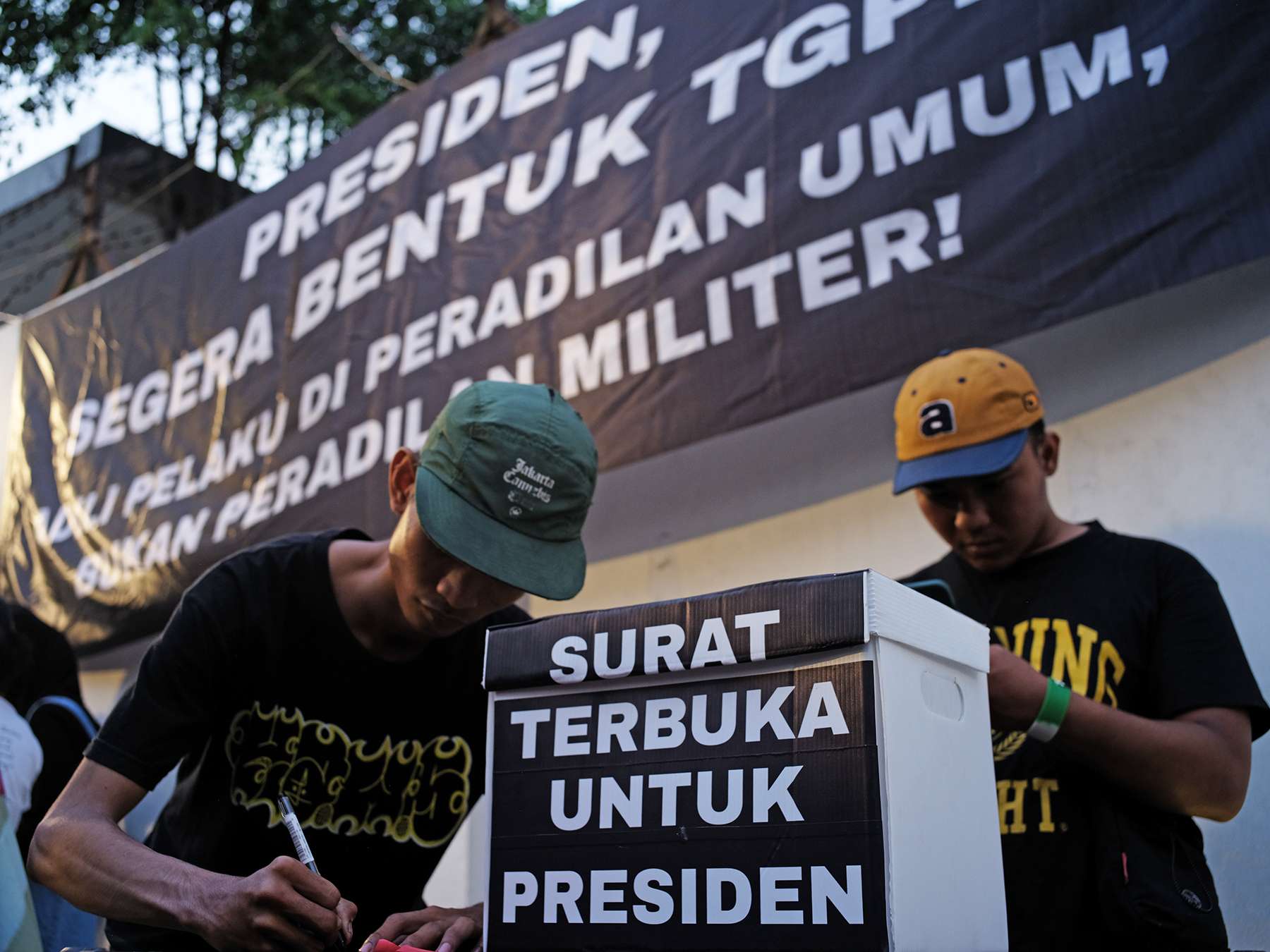 Participants at the “From the People for Andrie” solidarity concert in South Jakarta on April 27, 2026, write letters to President Prabowo Subianto. They call for an independent fact-finding team and civilian-court prosecution of the perpetrators and masterminds behind the acid attack on Andrie Yunus.