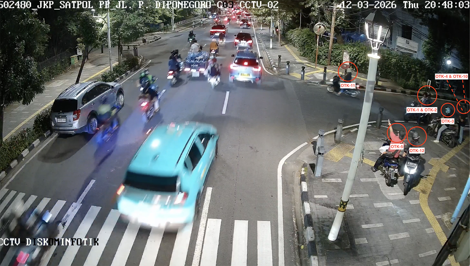 Suspect No. 12, identified as RD, speaks with Suspect No. 5 while wearing a helmet.