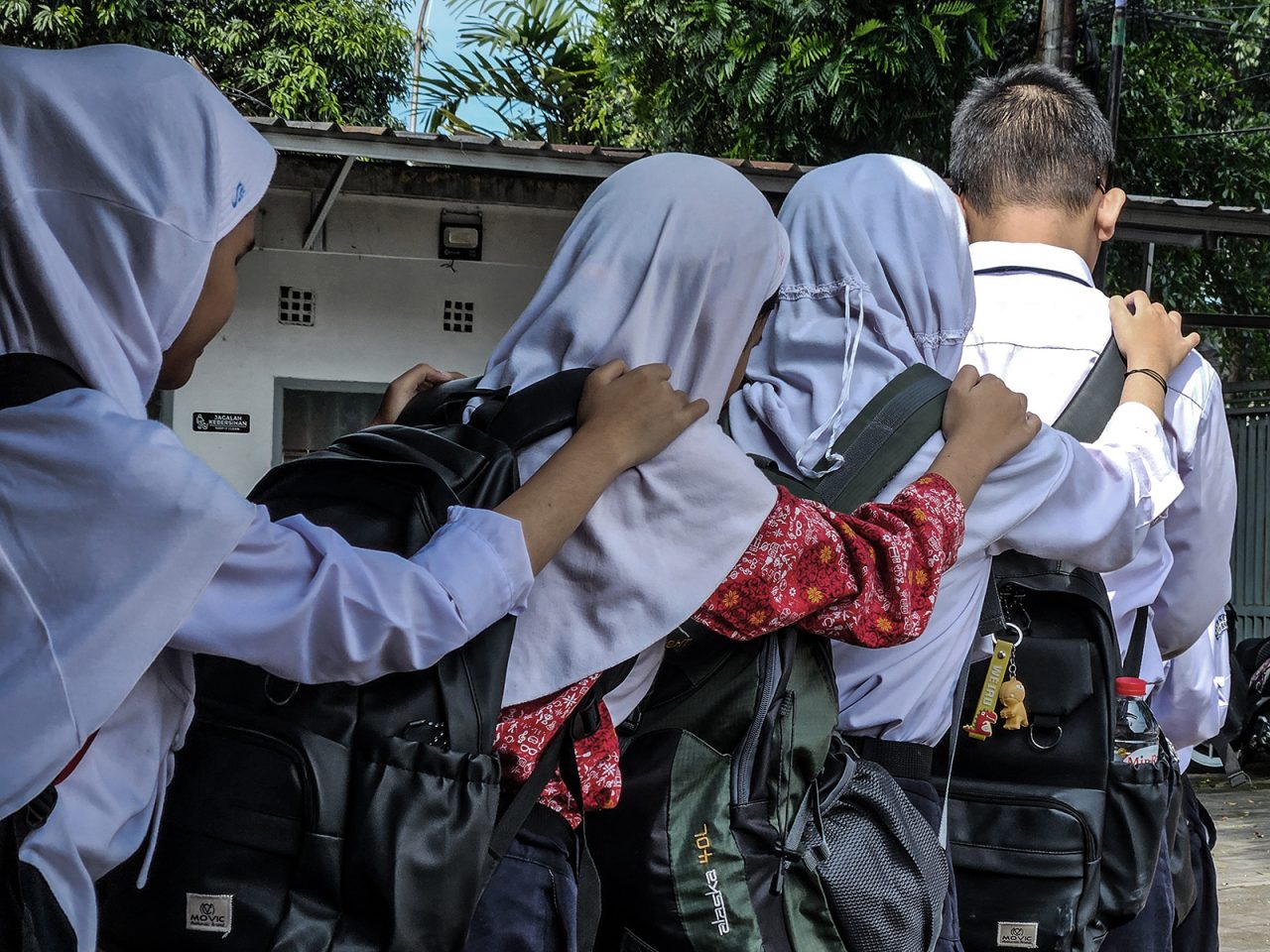 Murid tunanetra berjalan bersama saat pulang sekolah di SLB B Cicendo Bandung yang belum dilengkapi jalur pemandu. Murid SLB A Pajajaran terpaksa pindah ke SLB B Cicendo setelah gedung sekolah diambil alih untuk proyek Sekolah Rakyat rezim Prabowo. Mereka kehilangan lingkungan dan kesempatan untuk belajar kemandirian. (Project M/Virliya Putricantika)